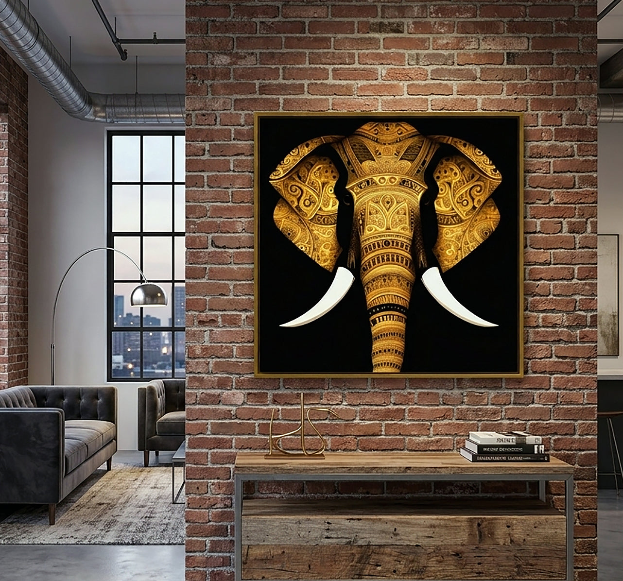 A framed wall art print of a golden elephant on a black background, displayed on a red brick wall above a wooden console table in a modern loft-style room.
