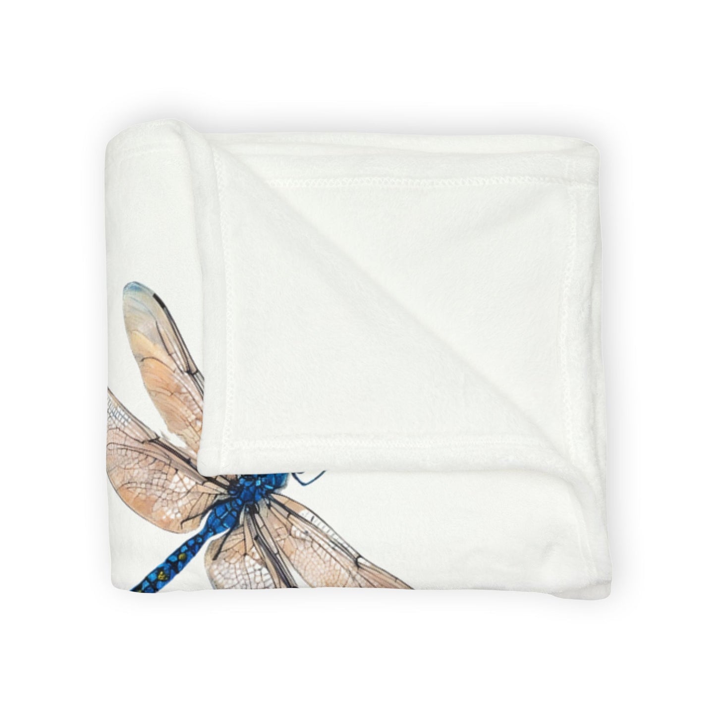 A folded white blanket featuring a printed illustration of a dragonfly with blue and tan wings, shown on a clean white background.