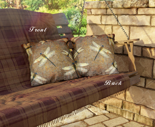 Wooden bench with plaid cushion and dragonfly-patterned pillows against a stone wall.