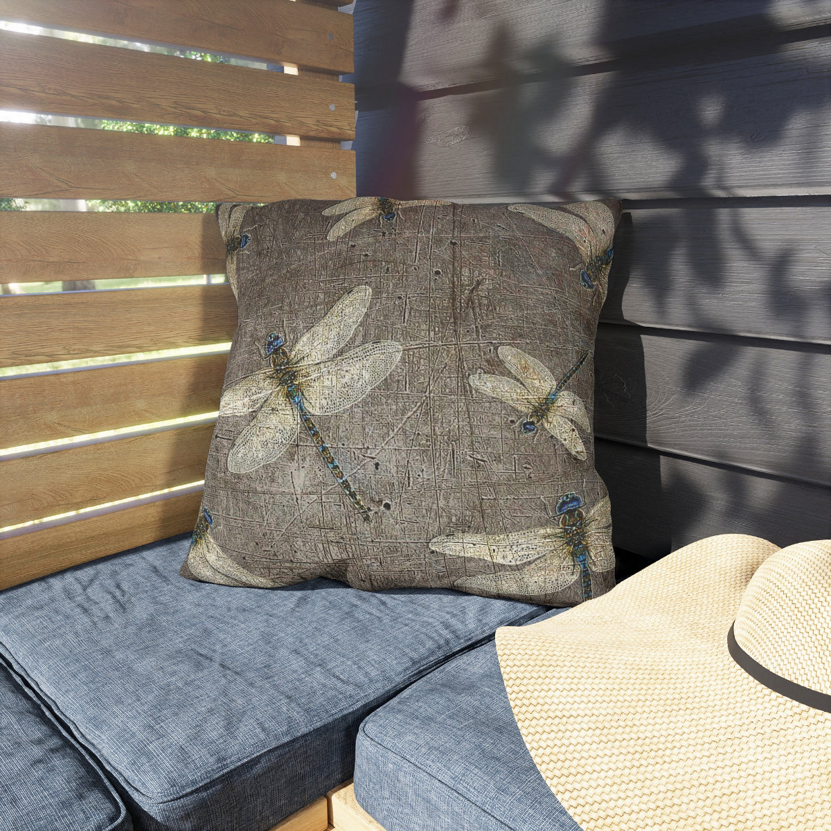 Decorative pillow with dragonfly pattern on a cushioned outdoor chair.