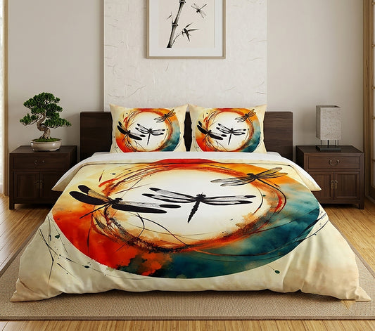 A bedding set displayed on a bed in a styled bedroom, featuring a duvet cover and two pillowcases with a watercolor-style dragonfly design in orange, teal, black, and cream.