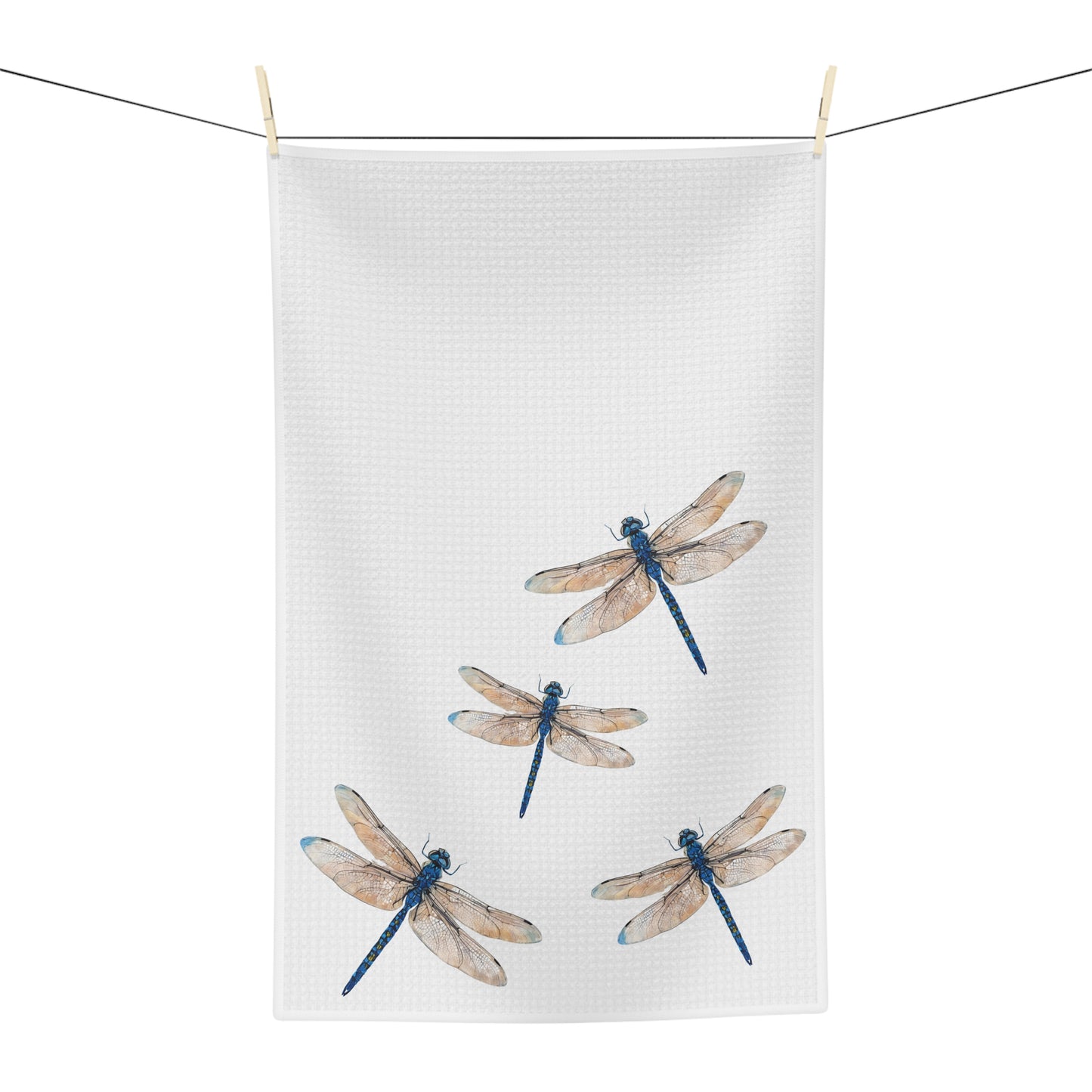 Tea towel with dragonfly design hanging on a line