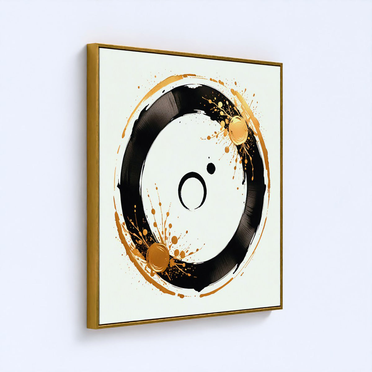 A framed abstract wall art print featuring a black circular brushstroke design with gold paint splatters on a white background, enclosed in a gold frame and shown hanging on a light gray wall.