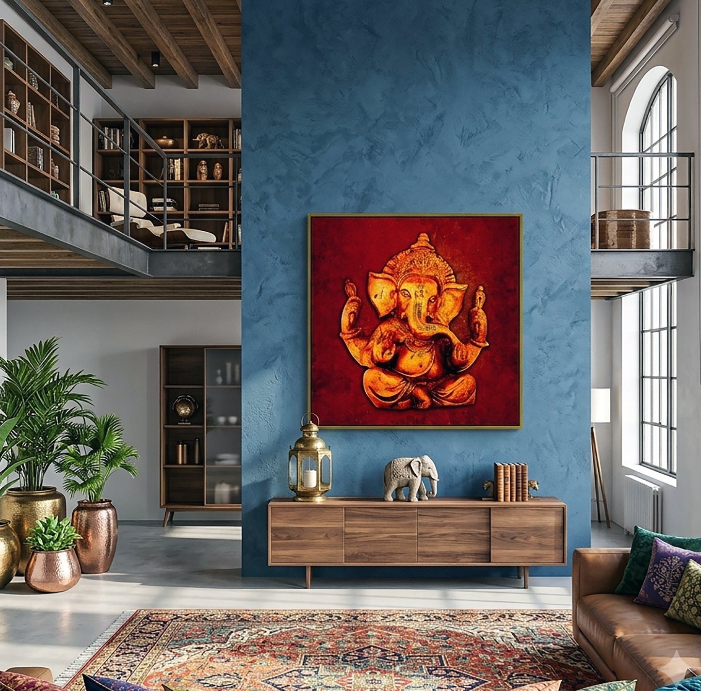 A large framed canvas art print of Lord Ganesha in gold and orange tones against a deep red background, displayed on a textured blue wall in a modern loft-style living room.