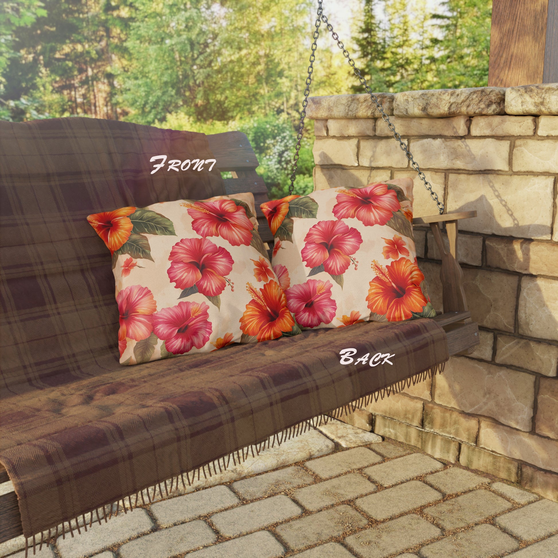 Outdoor swing with floral cushions and plaid seat cover on a stone patio.