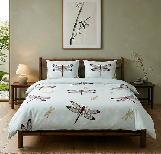 A light blue bedding set with a dragonfly pattern, styled on a wooden bed frame in a modern, minimalist bedroom with a bamboo print on the wall.