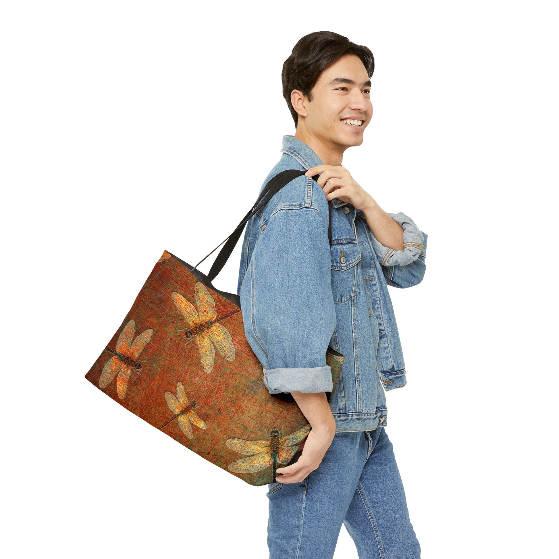 Man carrying a large tote bag with dragonfly design on a brown background