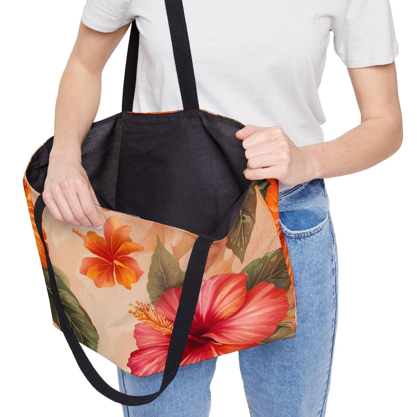 Person holding a hibiscus flower print tote bag with a black inside