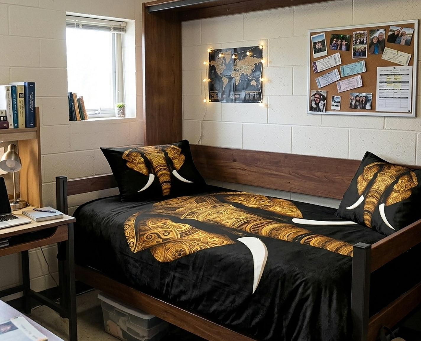 A bed in a dorm room styled with a black and gold elephant print comforter and matching pillows, set against a white cinderblock wall with a desk and shelves.
