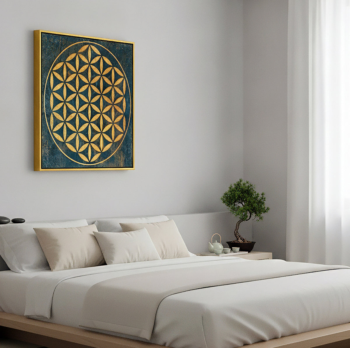 A square framed wall art print featuring a gold geometric flower of life design on a dark blue textured background, hanging on a light gray wall above a minimalist bed in a bright, modern bedroom.
