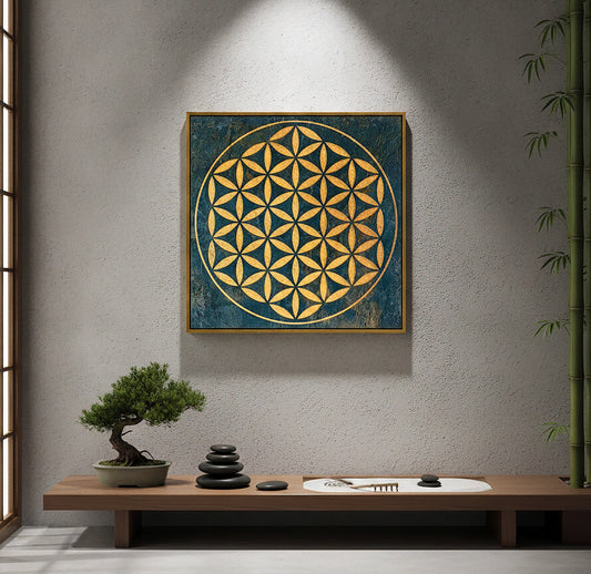 Square framed wall art featuring a gold geometric flower-of-life pattern on a dark blue textured background, displayed on a textured gray wall above a wooden bench with a small bonsai tree and zen stones.