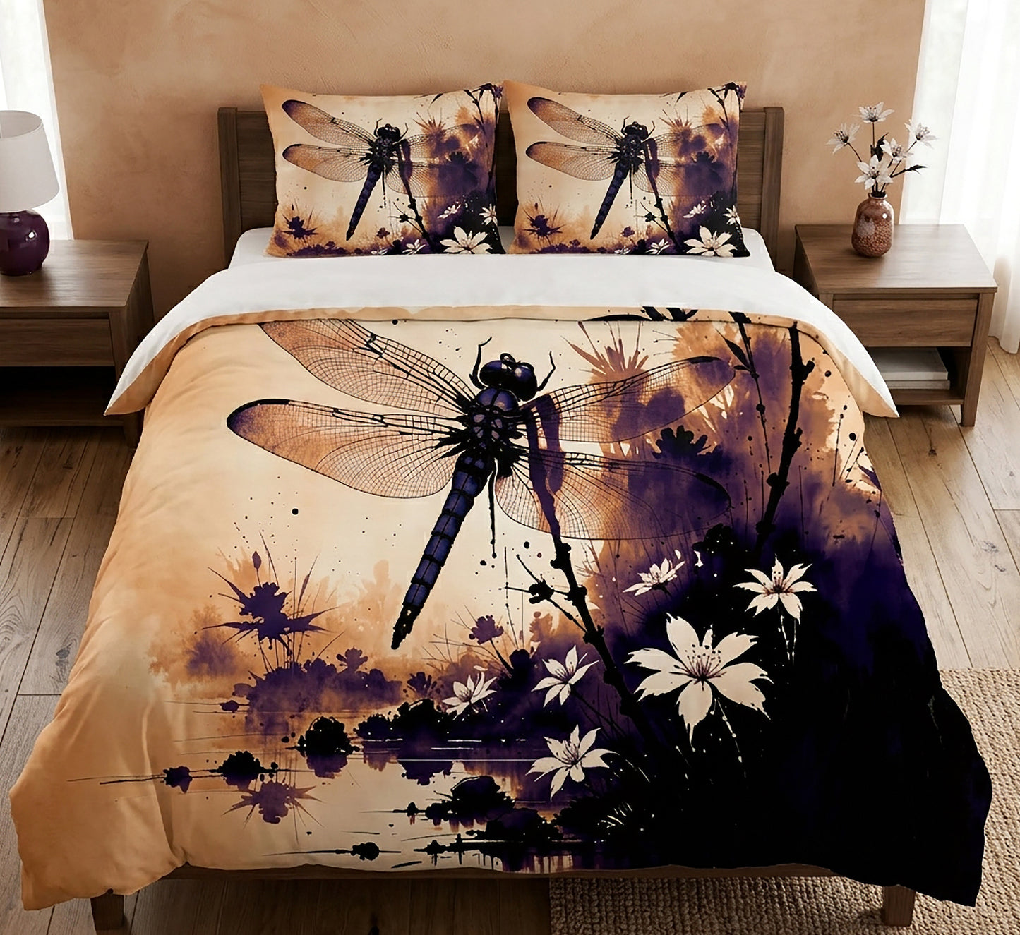 A bed dressed in a printed duvet cover and two matching pillowcases featuring a large dragonfly and floral artwork in black, purple, and warm beige tones, shown in a styled bedroom setting.