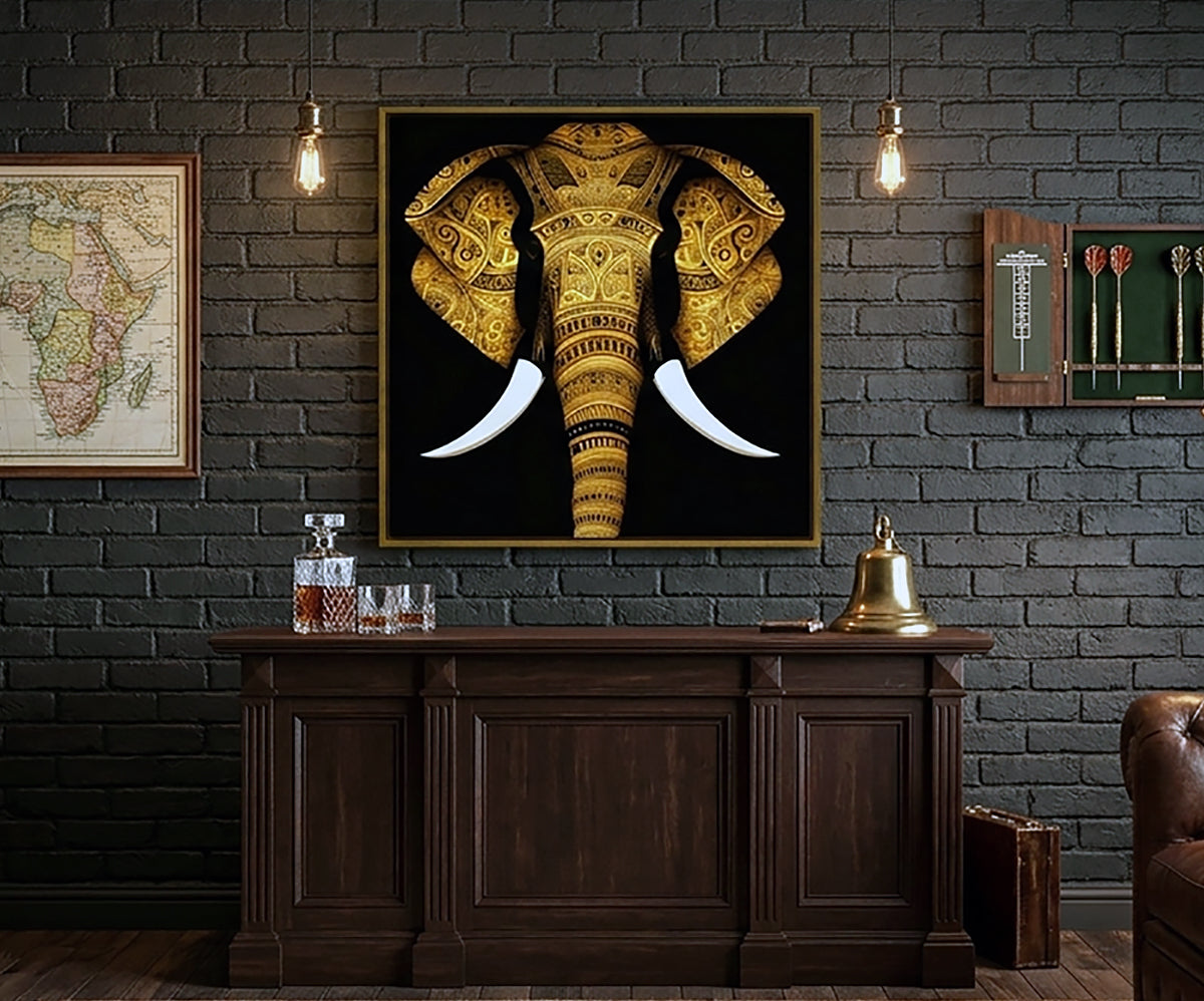 A framed wall art print featuring a golden elephant head with white tusks on a black background, displayed above a dark wood console in a room with a dark brick wall and hanging lights.