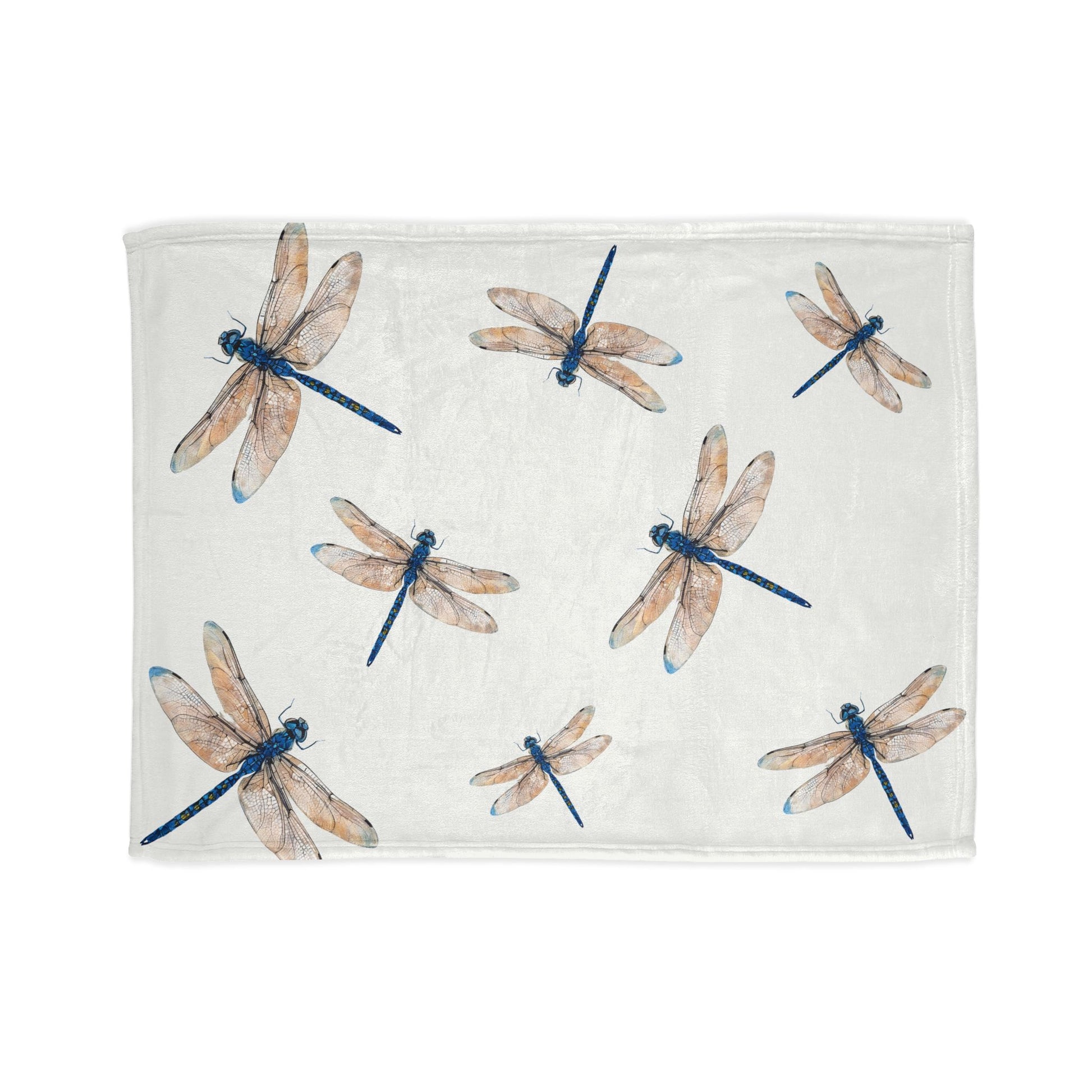 A rectangular white towel or blanket featuring a watercolor-style print of dragonflies in blue and beige, shown flat against a white background.