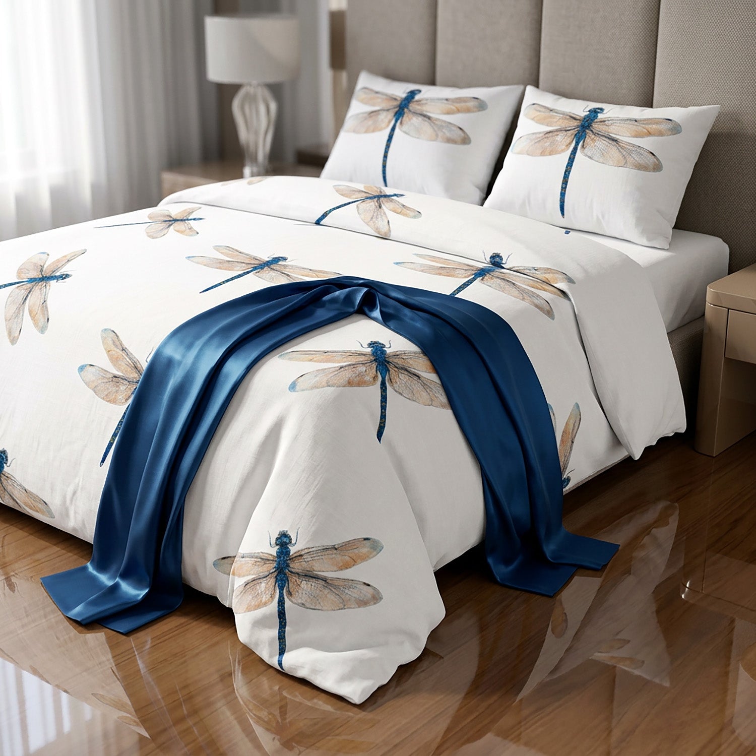 Bed with dragonfly patterned bedding and blue blanket in a bedroom setting.