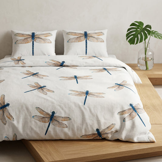 Dragonfly-patterned bedding set on a bed with a plant in the background