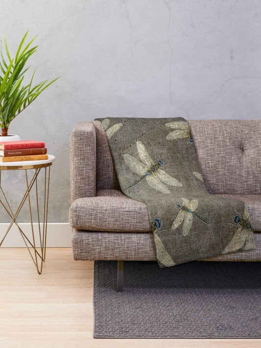 Dragonfly themed blankets, flight of dragonflies on distressed stone gray background printed on minky blanket on sofa